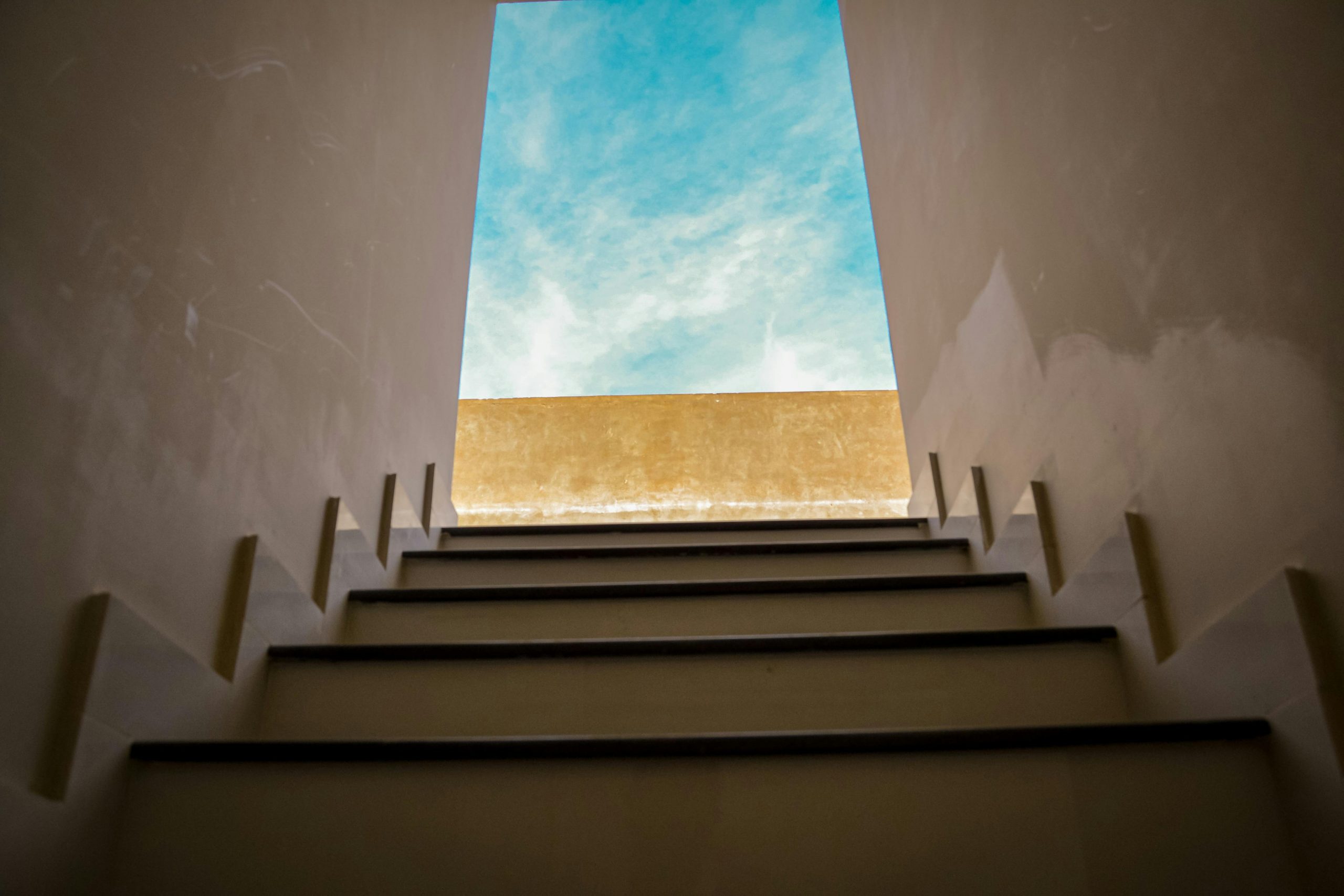 Stairway leading upward to bright blue sky symbolizing new leader confidence and professional growth