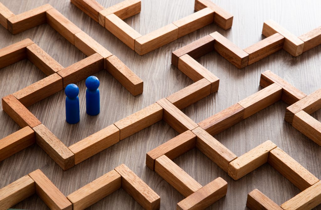 Two small figures navigating a complex wooden maze